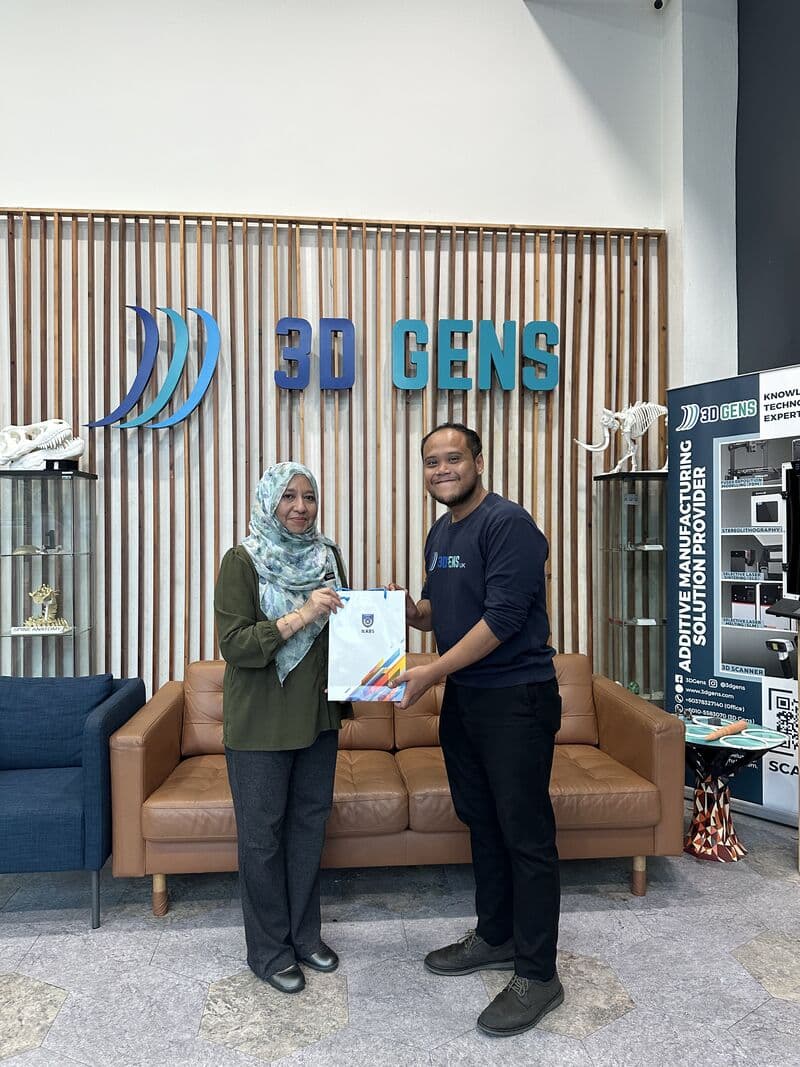 IKTBN representative exchanges a souvenir bag with a 3D Gens team member at the 3D Gens facility during the MoU engagement visit