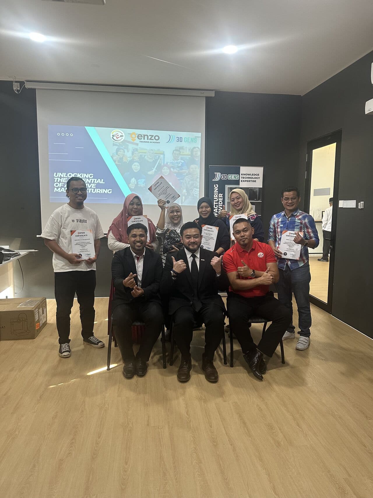 3D printing training graduates celebrate with their Enzo Training Academy certificates alongside 3D Gens trainers