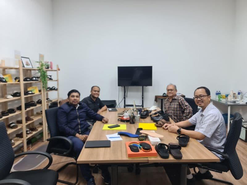 3D Gens and XES Malaysia representatives in a product discussion meeting, with footwear samples and sole components on the table